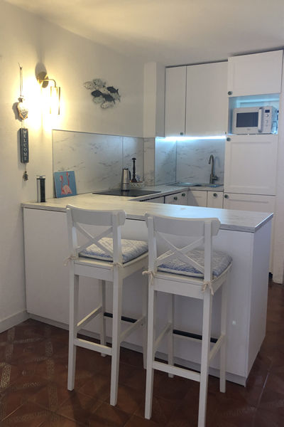 Full kitchen area with breakfast bar and two stools